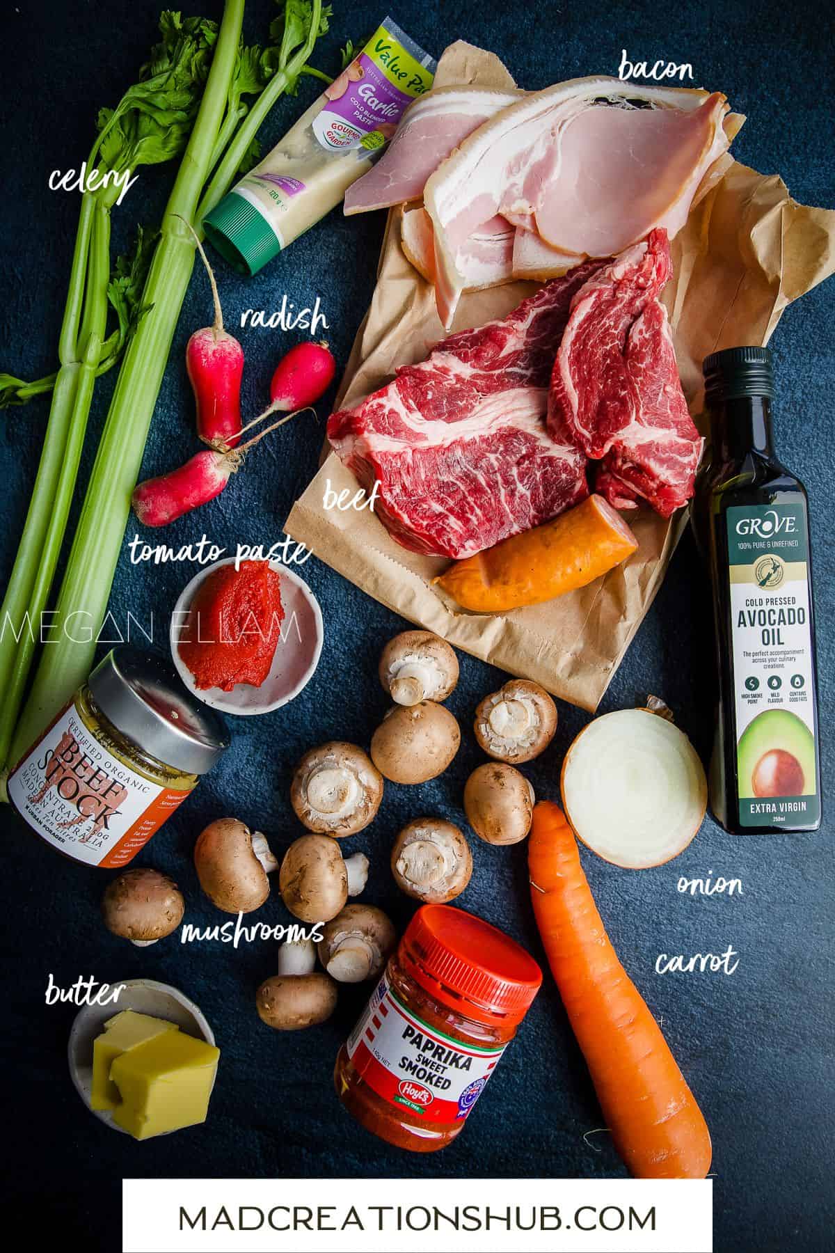 All the ingredients laid out for a Keto Beef Stew on a blue back drop.
