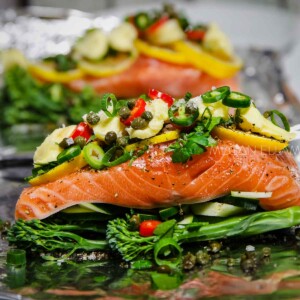 A close up of salmon with mayonnaise on a sheet of foil ready to be baked.