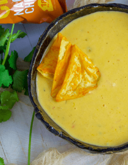 Chile Con Queso Dip in a black bowl with protein chips