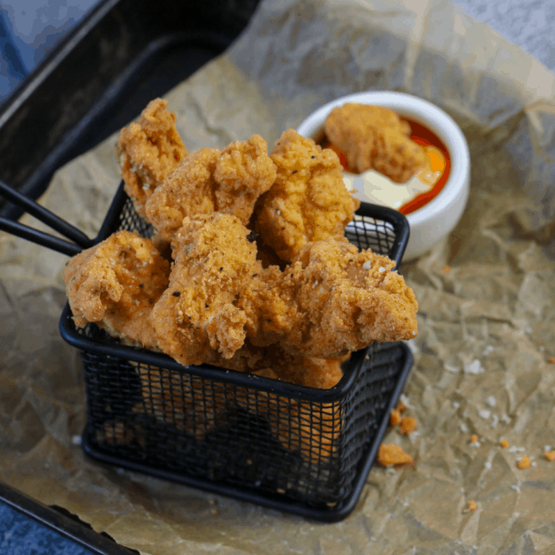 Lightly crumbed chicken in fry basket
