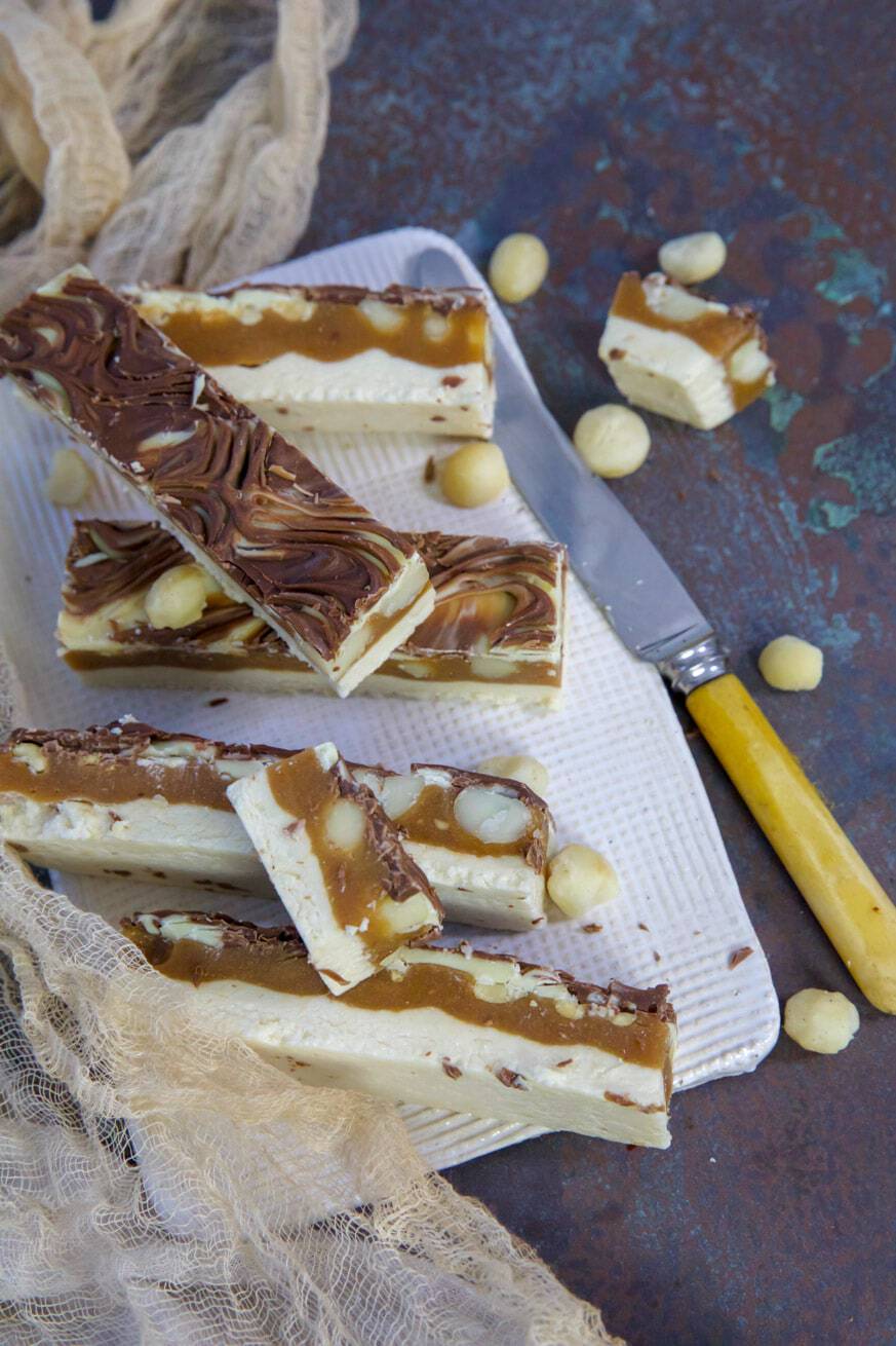 caramel chew bars on a white platter with knife