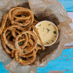Keto Onion Rings in brown paper on wood background.