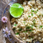 Cauliflower rice in a brown bown with lime and flowers