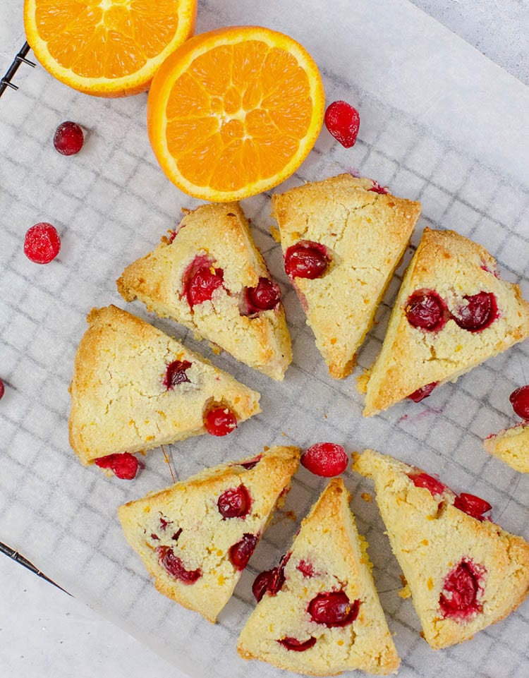 Keto orange cranberry scones on a wire rack with cranberries scattered