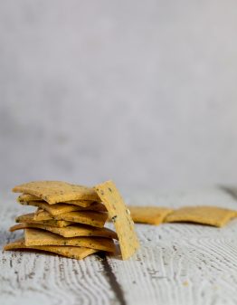 keto cheese crackers scattered on white wood
