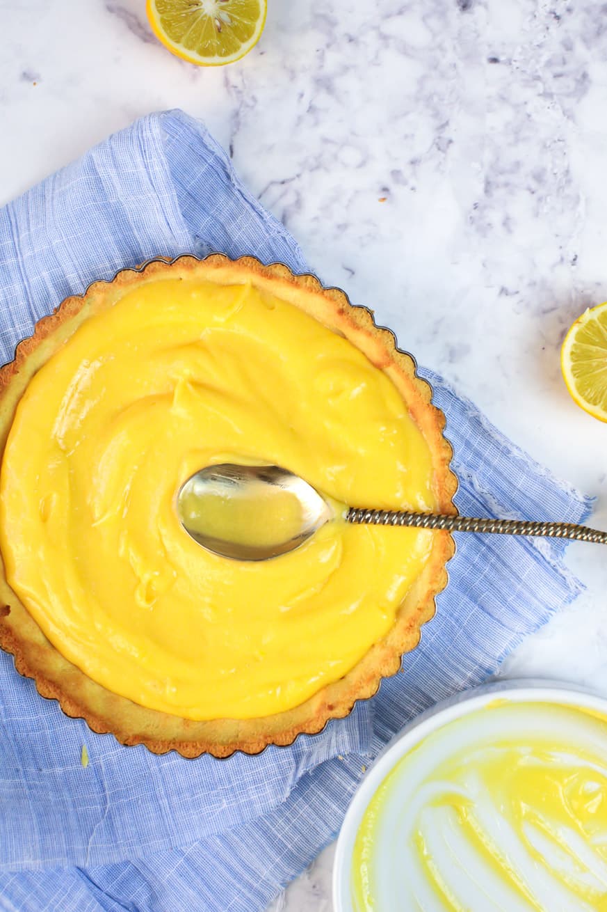 lemon curd in a keto pie shell on a whote backdrop