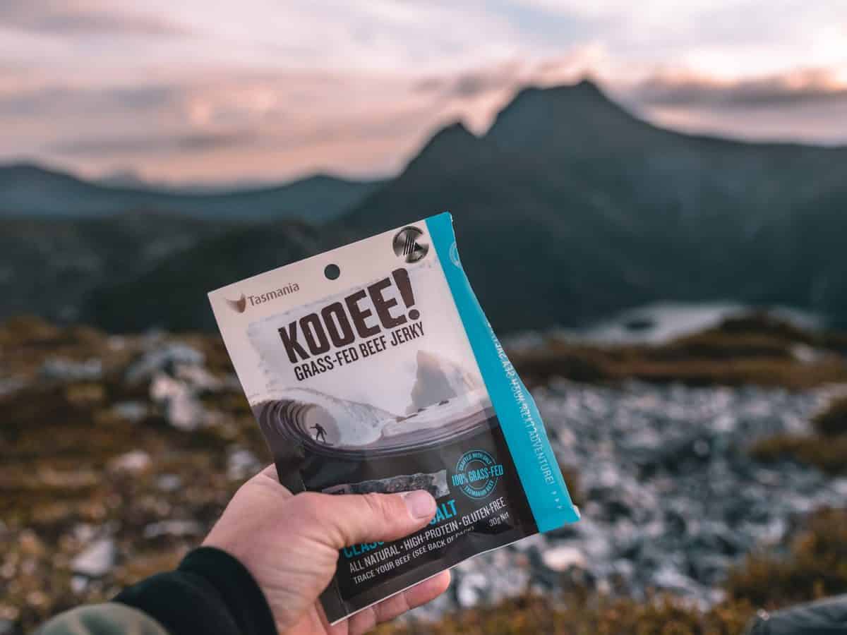 Kooee jerky in a hand with landscape background