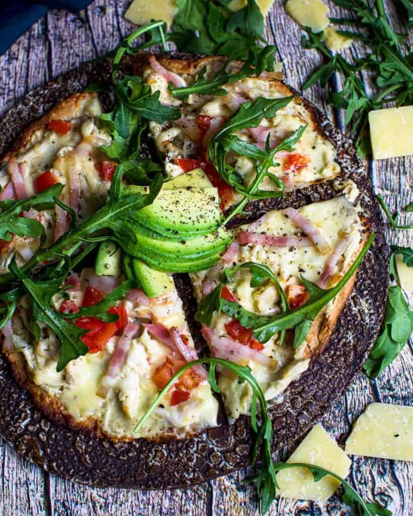 Chicken pizza with avocado and rocket on top