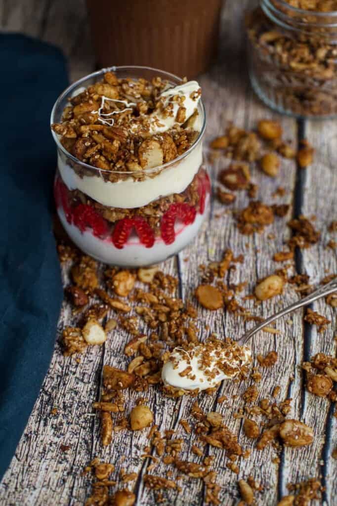 spoon with cream and granola on a wood table