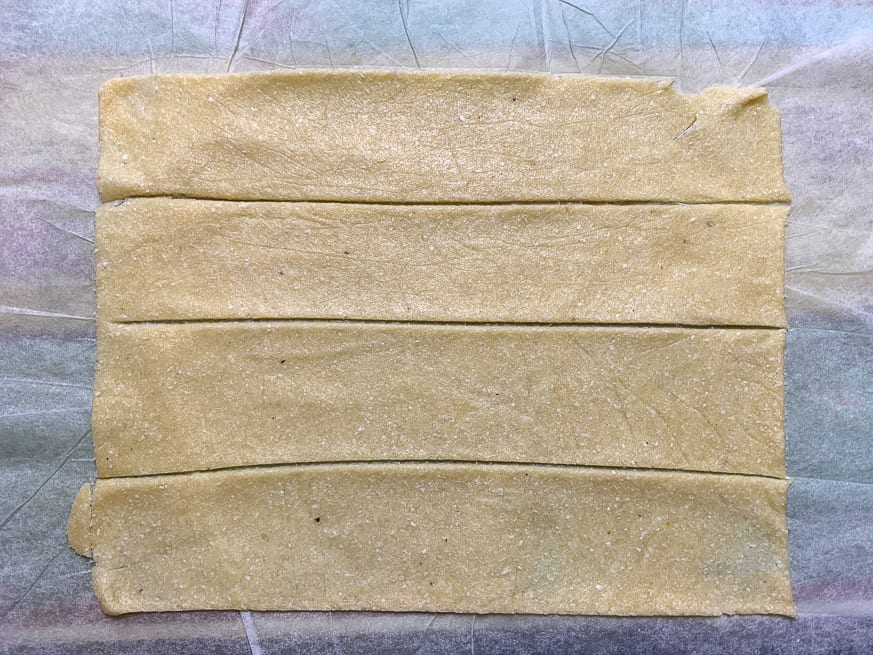 square of dough with 4 lines cut into it