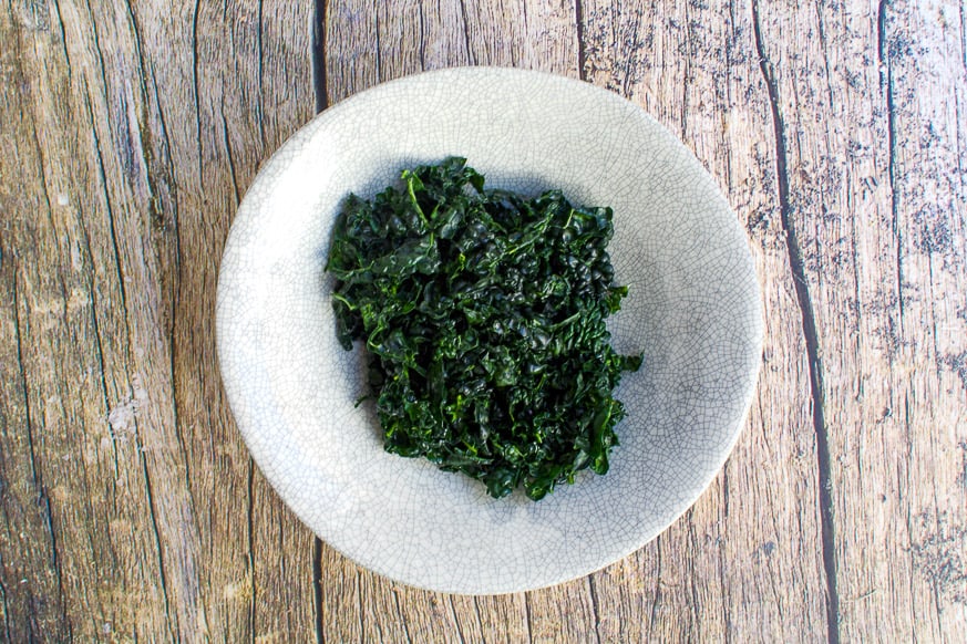 bowl of kale on a wood table