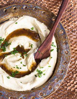 creamy cauliflower mash and gravy in a bowl with spoon