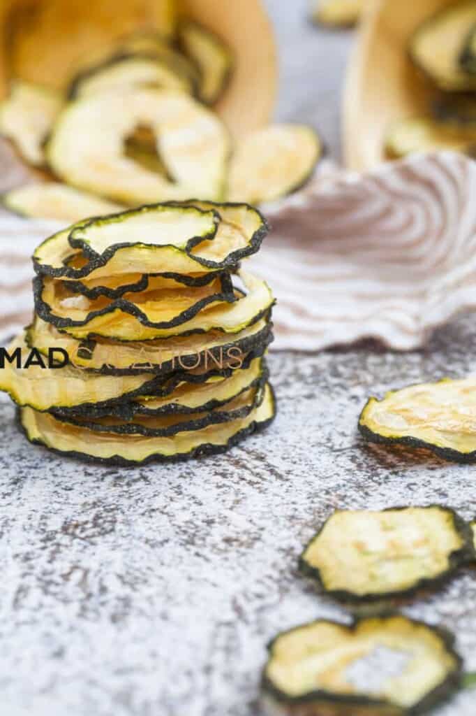 a stack of zucchini chips on a speckled table