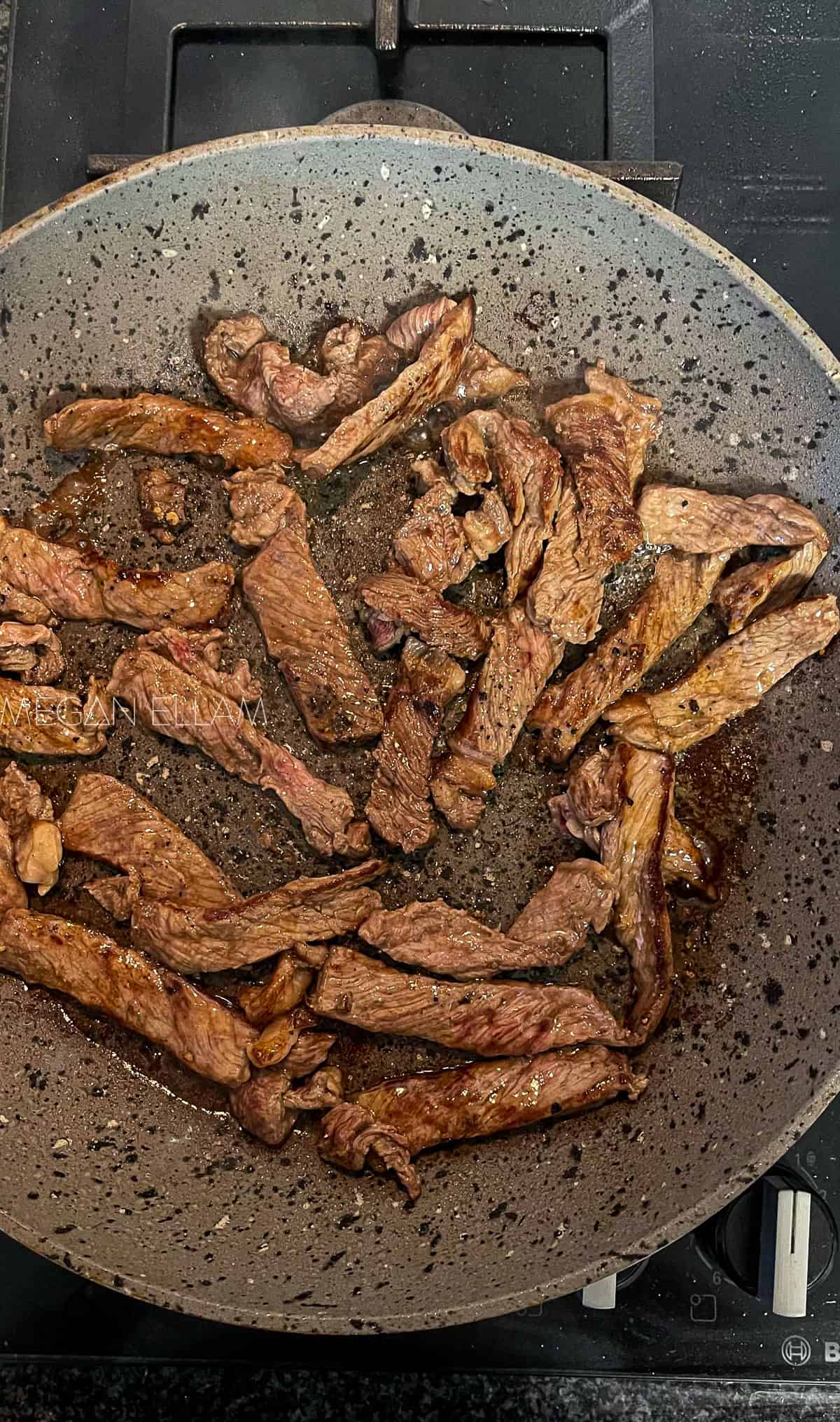 beef strips in a frying pan.