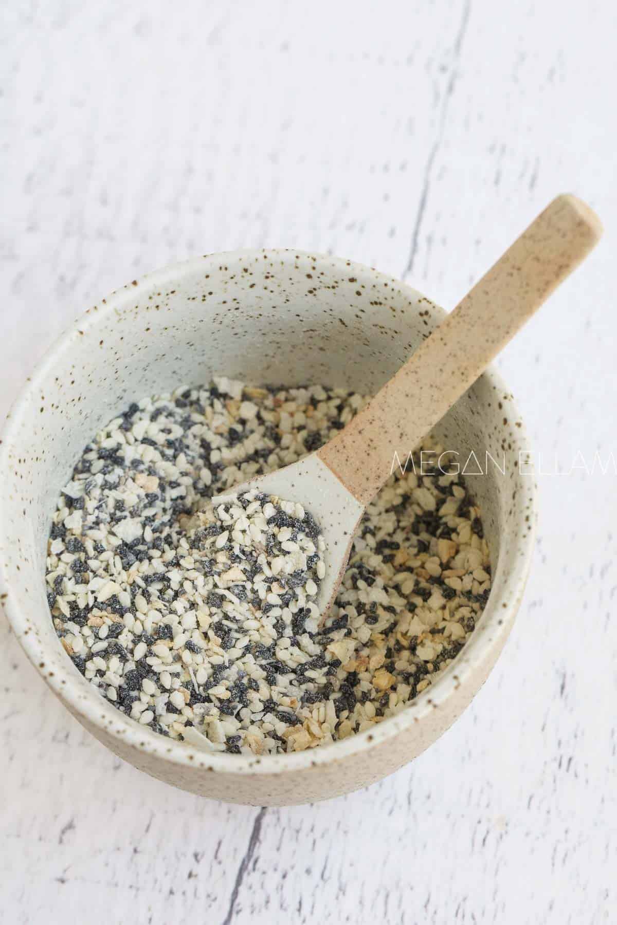 A bowl filled with everything but the bagel seasoning and a spoon.