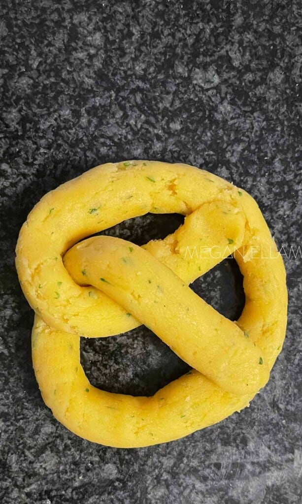 A raw pretzel on a kitchen bench.