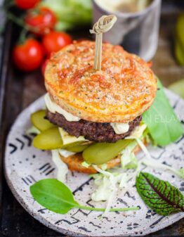 A burger and salad on a grey plate.