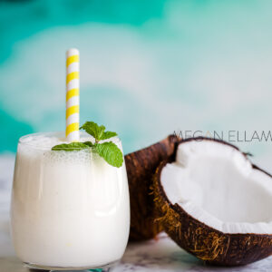 A shake and a coconut on a kitchen benchtop.
