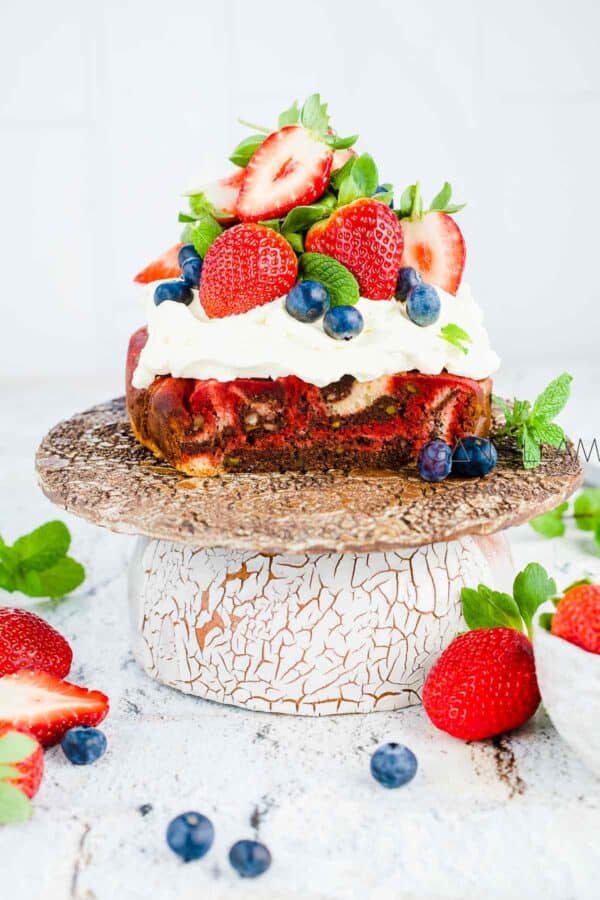 Marbled Mud Cake with whipped cream and berries on top.