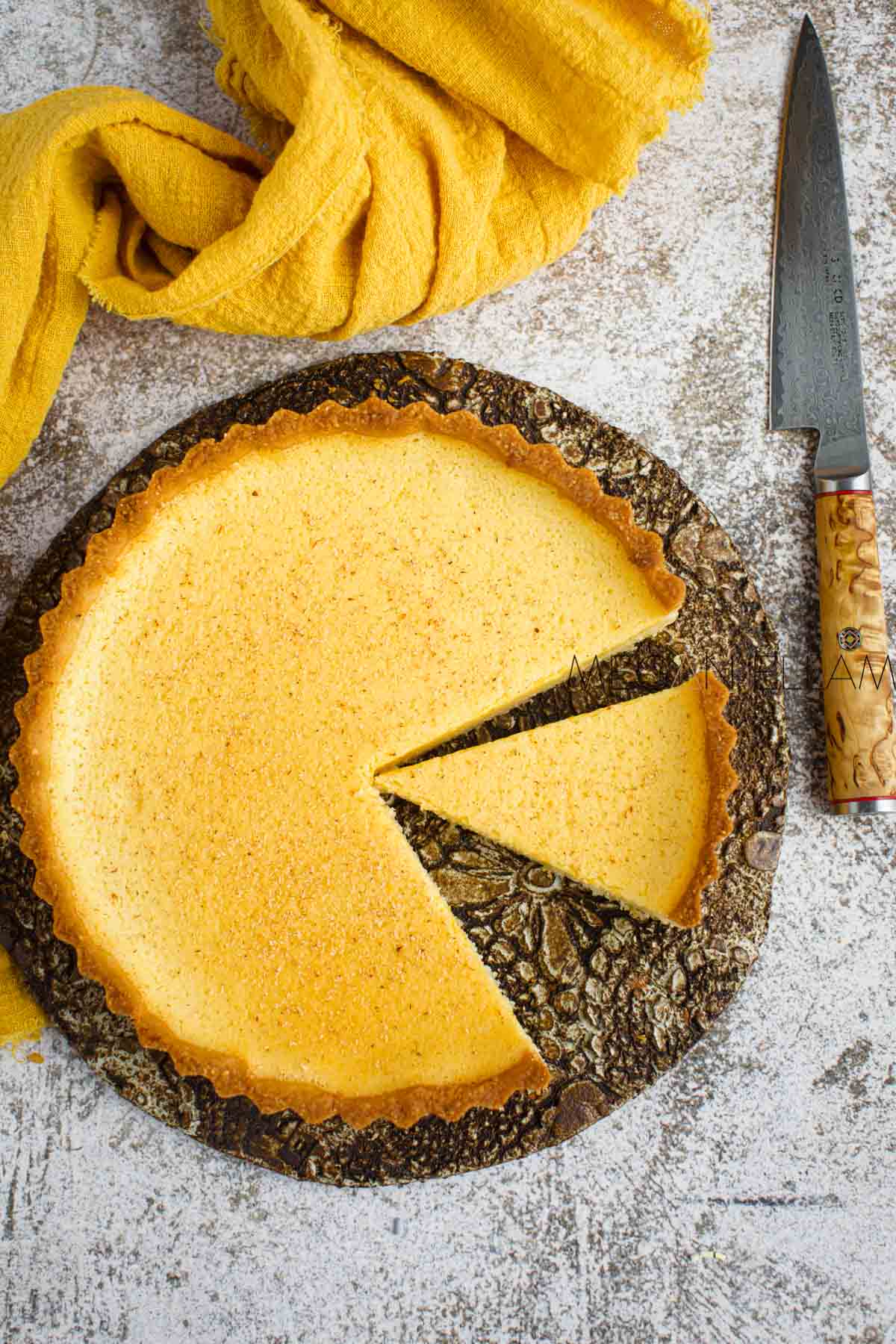 A custard pie with two slices cut out of it.