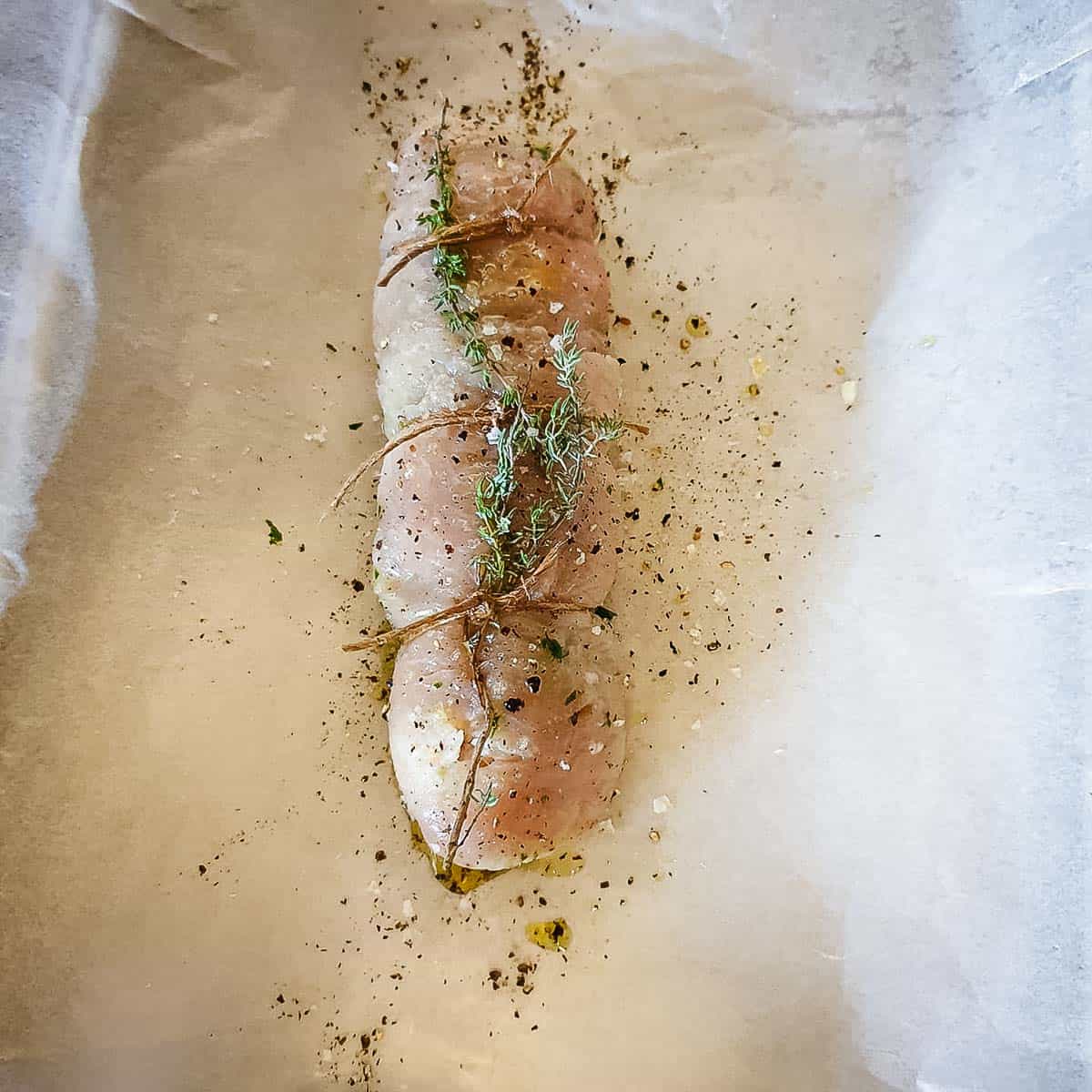 A rolled turkey breast secured with twine and seasoned with spices and herbs