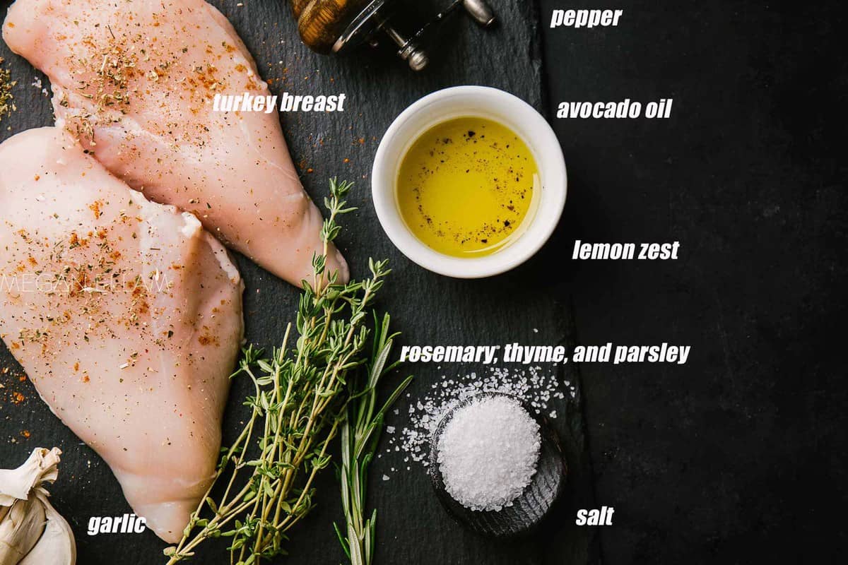 A dark background with seasoned turkey breasts and the ingredients laid out around them.