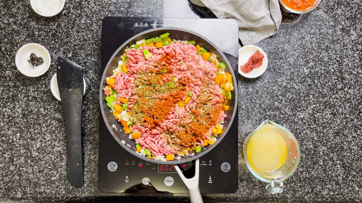 Ground beef and diced vegetables in a frying pan.