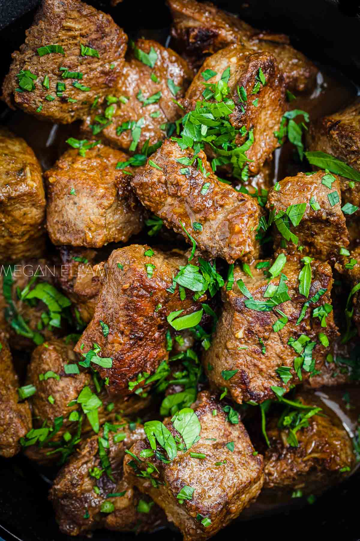 Steak bites with parsley on top.