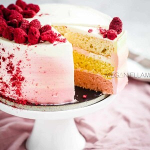A pink ombre keto cake with freeze-dried raspberries on top.