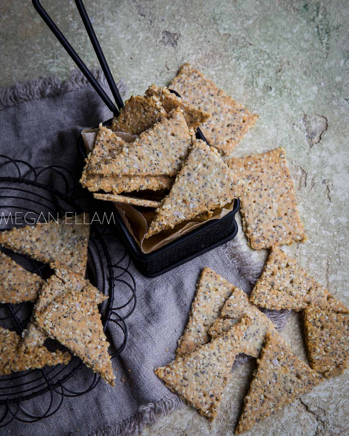 Keto crackers in a small fry basket and others scattered around it.