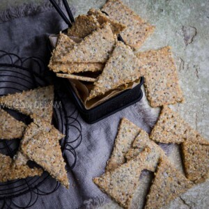 Almond Flour Crackers scattered on cooling racks and a small lined frying basket.
