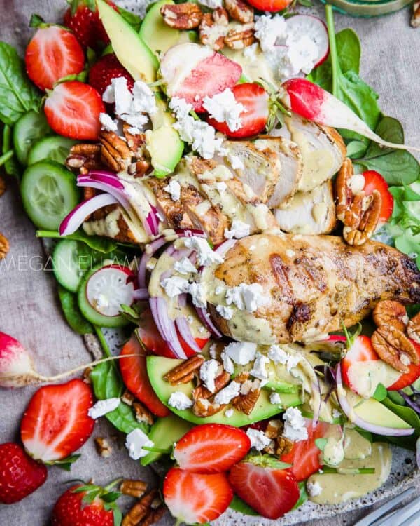 A chicken and strawberry salad on a platter.
