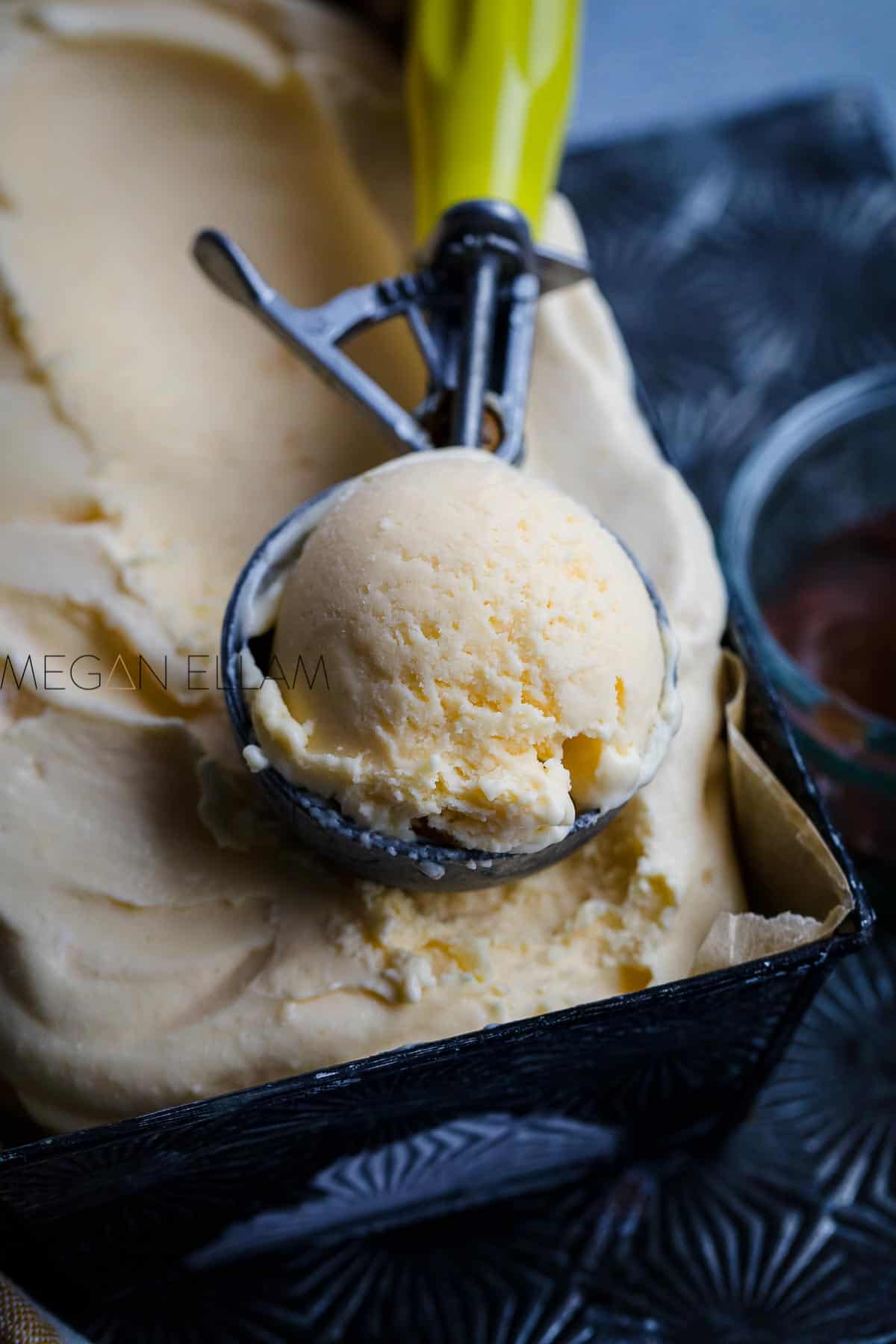 An ice cream scoop of the creamiest protein ice cream recipe in a loaf pan filled with the ice cream.