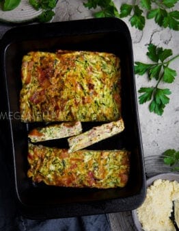 A black baking dish with a zucchini slice in it chopped into 4 pieces.