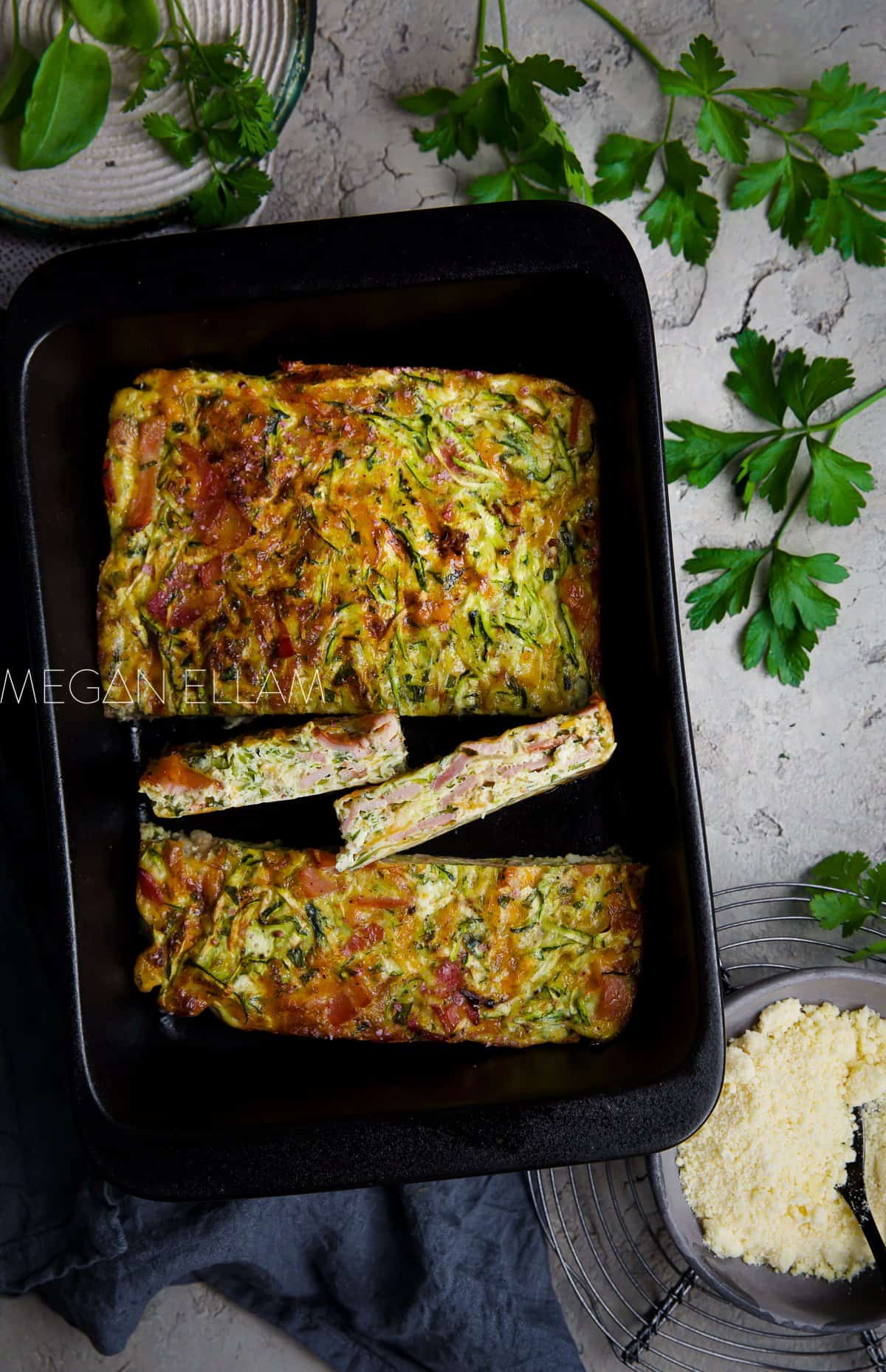 A black baking dish with a zucchini slice in it chopped into 4 pieces.