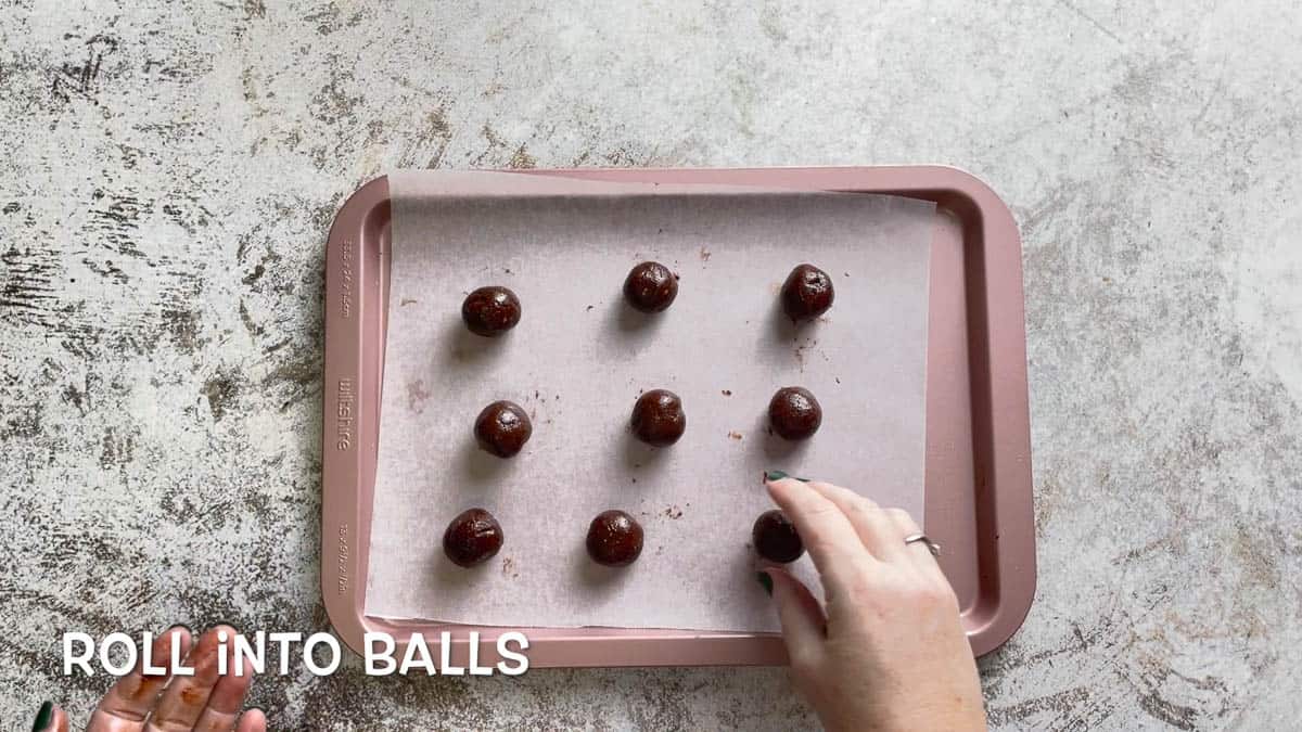Small keto truffles on parchment paper on a baking tray.