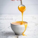 Sugar Free Caramel Syrup pouring off a spoon into a small white bowl.