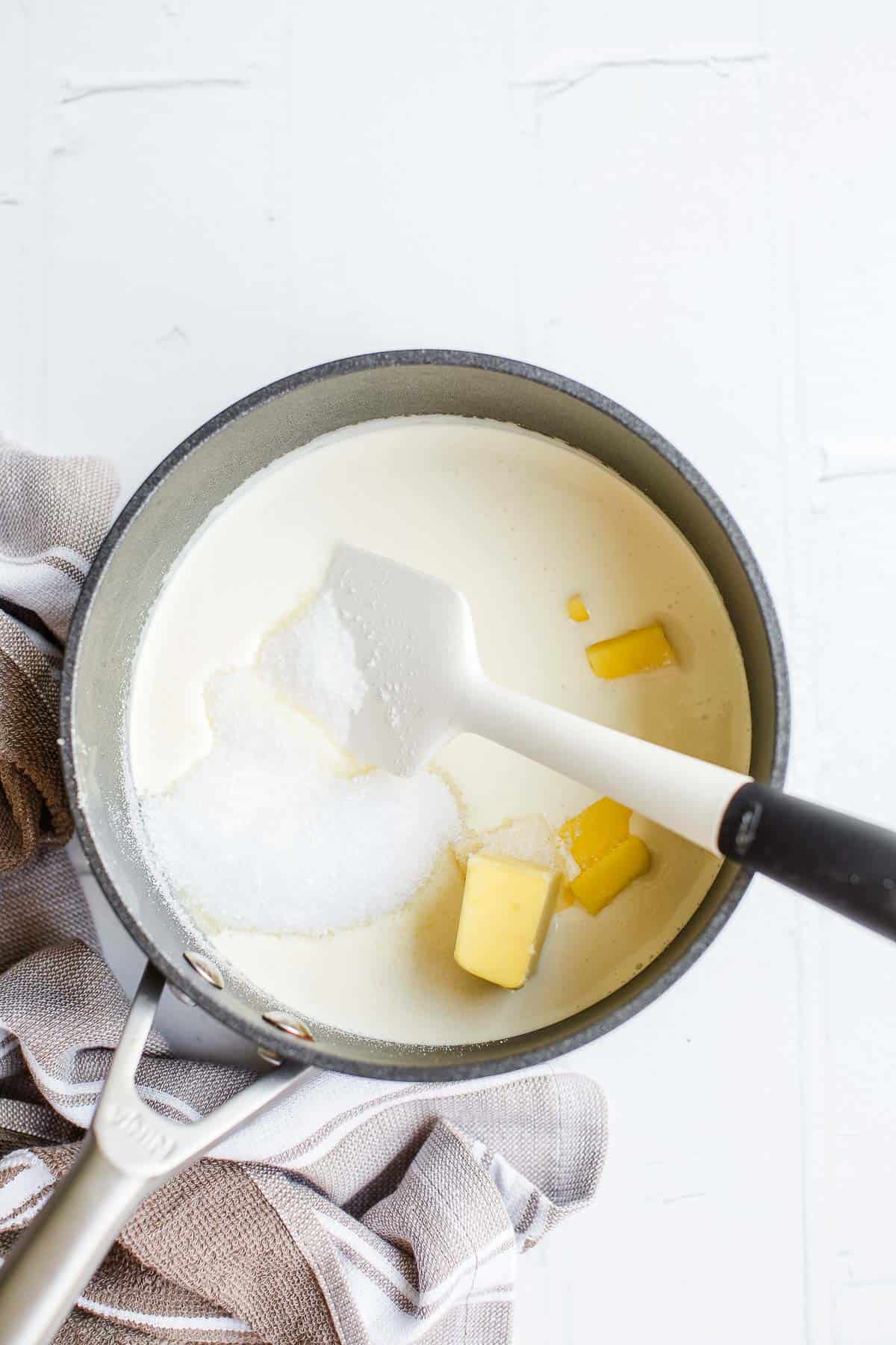 Cream butter and sweetener in a small saucepan with a white spatula.