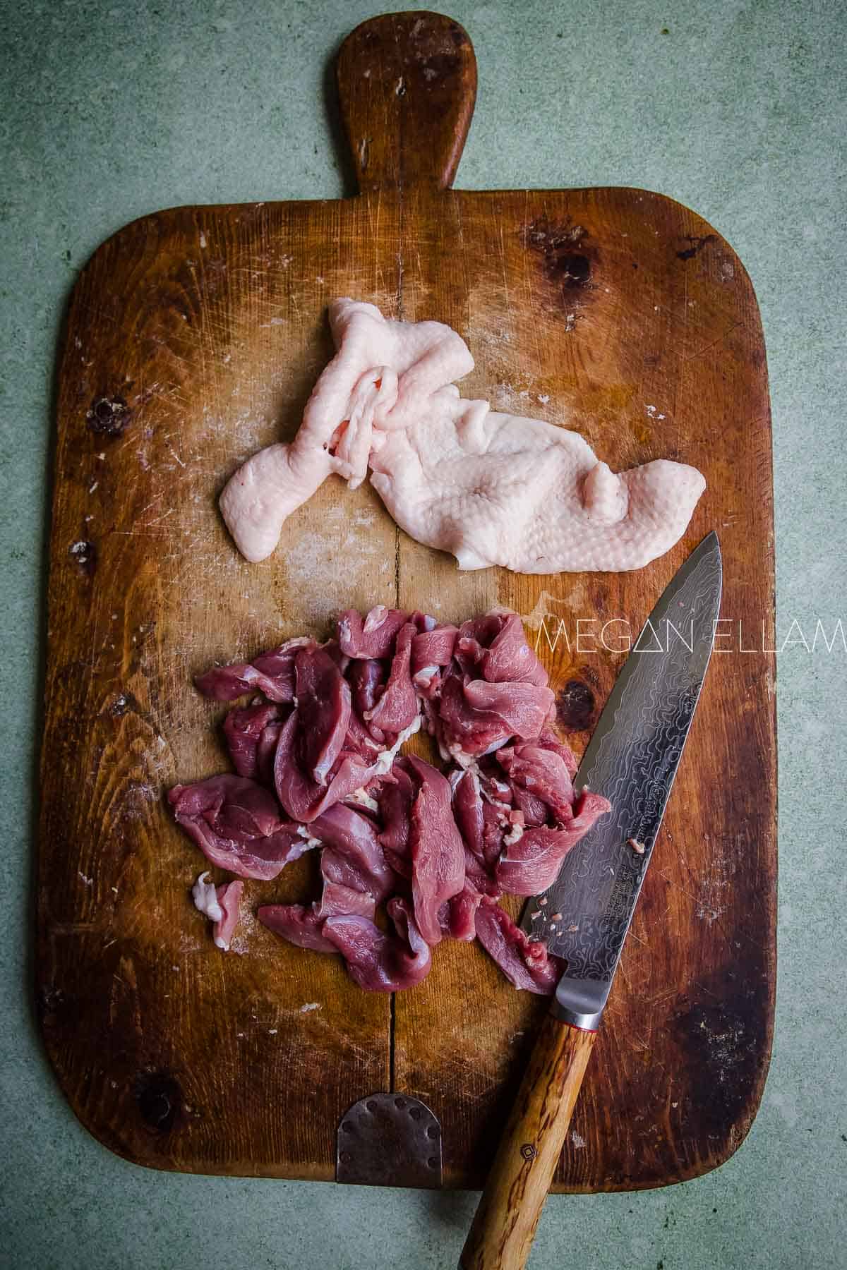 Sliced duck breast on a chopping board.