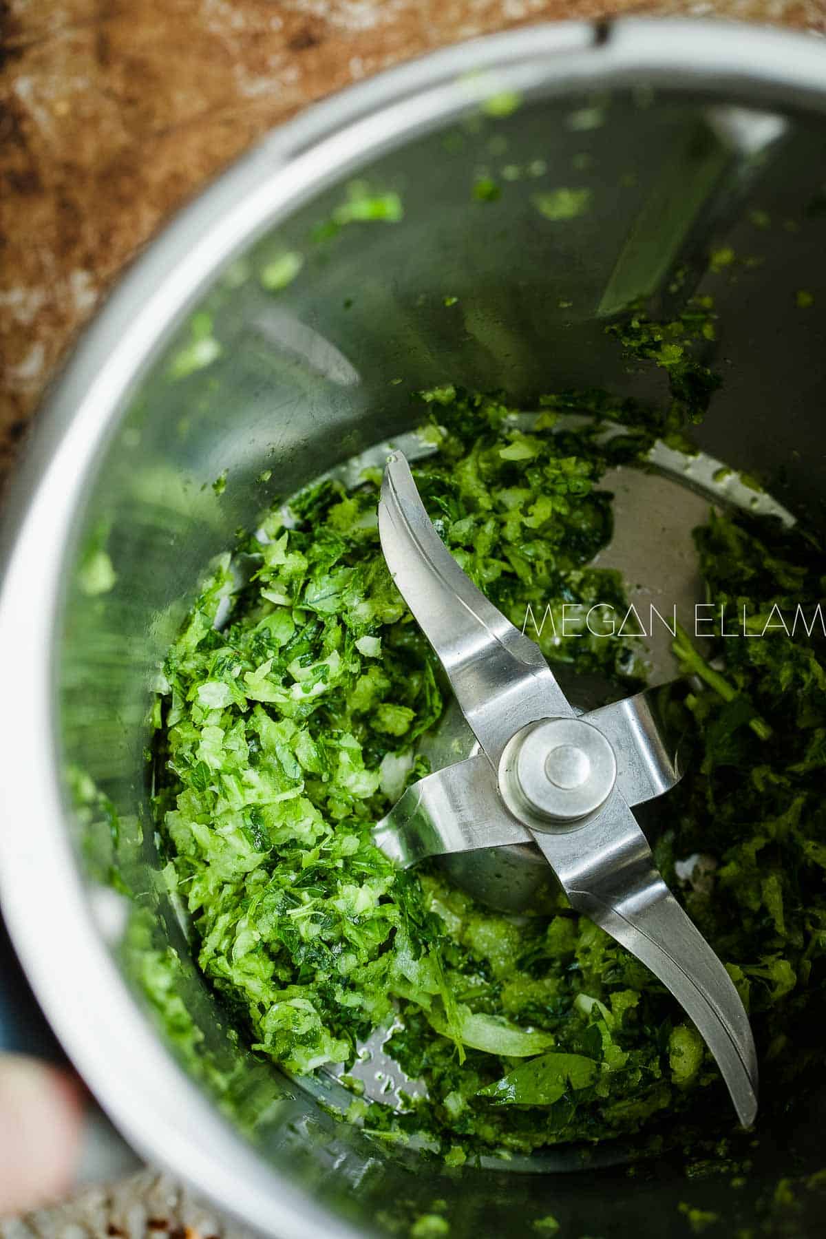 Onion and parsley in a Thermomix bowl.