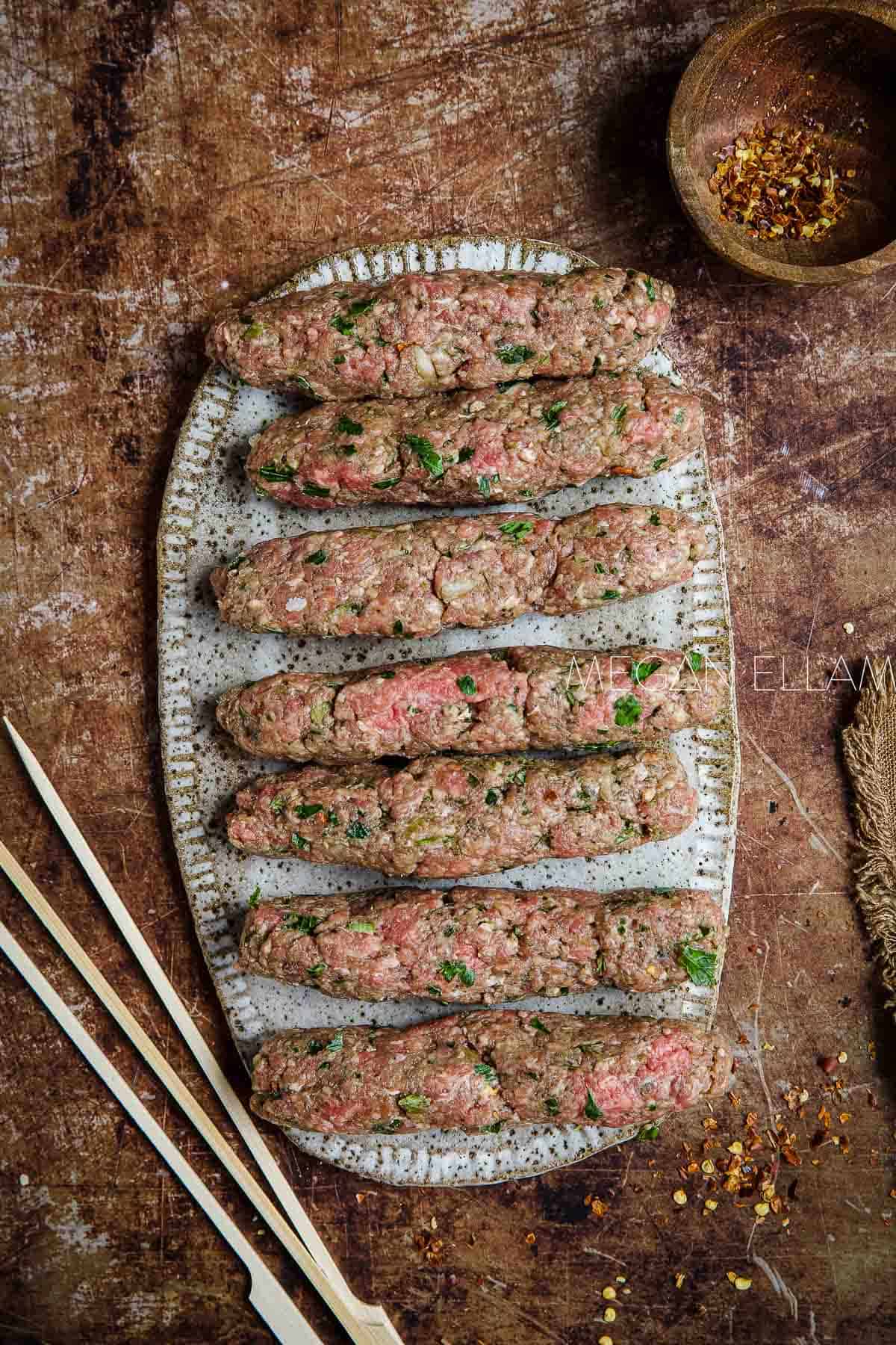 7 Kafta kebabs shaped into oblong-shapes.