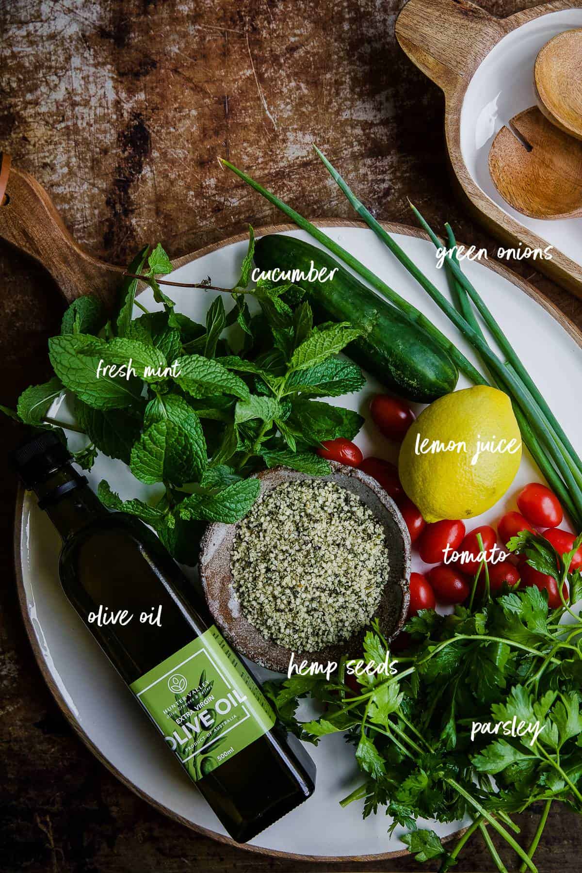 Taboule ingredients on a white platter with labels.