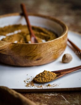 Lebanese 7 Spice (Baharat) in a mango wood bowl with a spoonful in front.