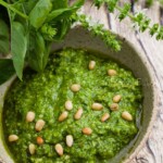 A close up of Basil di Basilico in a bowl with basil to the left.