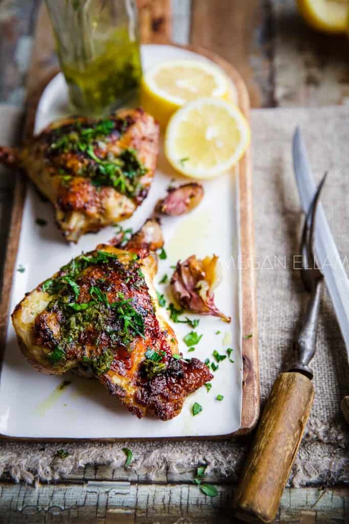 Baked Italian Chicken on a white and wood platter.