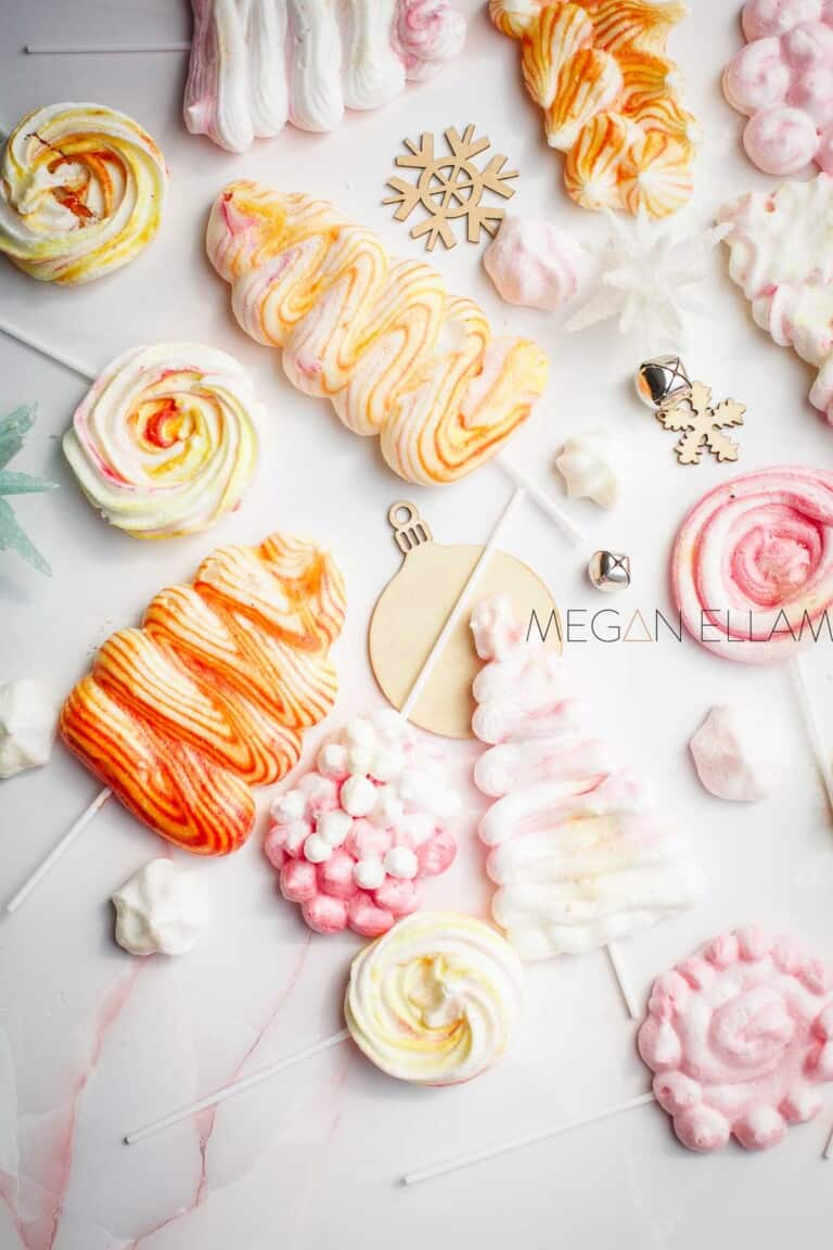 Lots of meringue cookies scattered around on a white background.