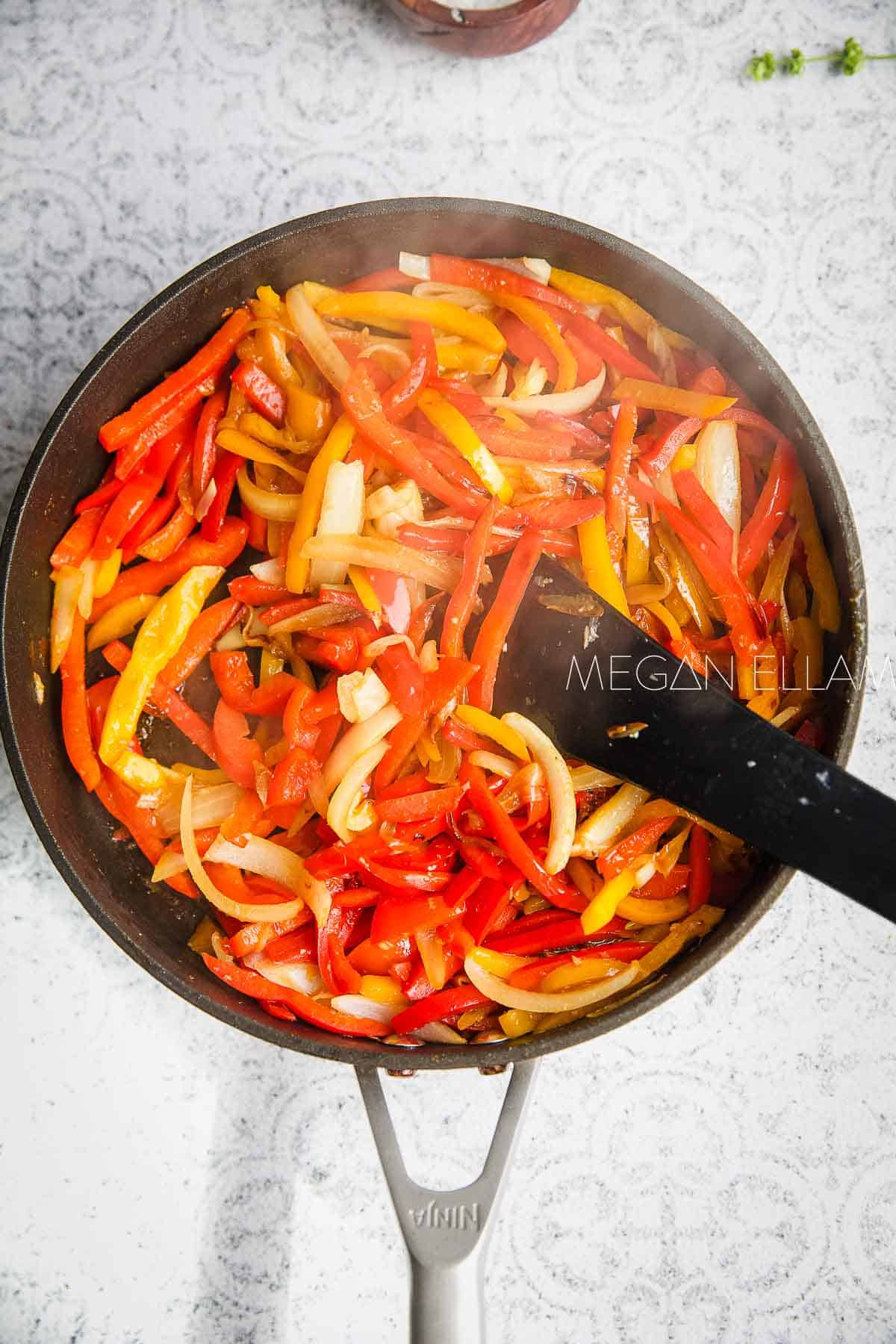 Sauteeing bell peppers for Italian stew in a skillet.