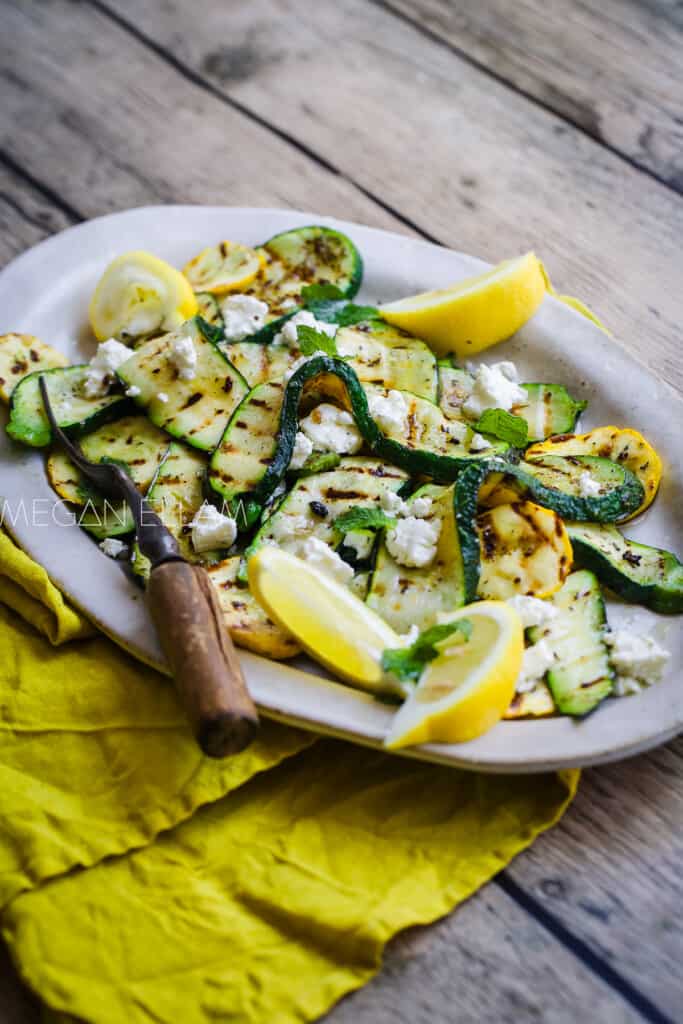 Grilled Zucchini and Yellow Squash on an oval platter with a lime te towel.