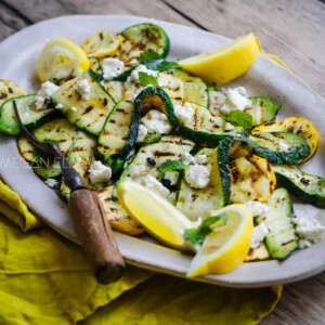 Grilled Zucchini and Yellow Squash on a large ovel platter with a rusty fork.