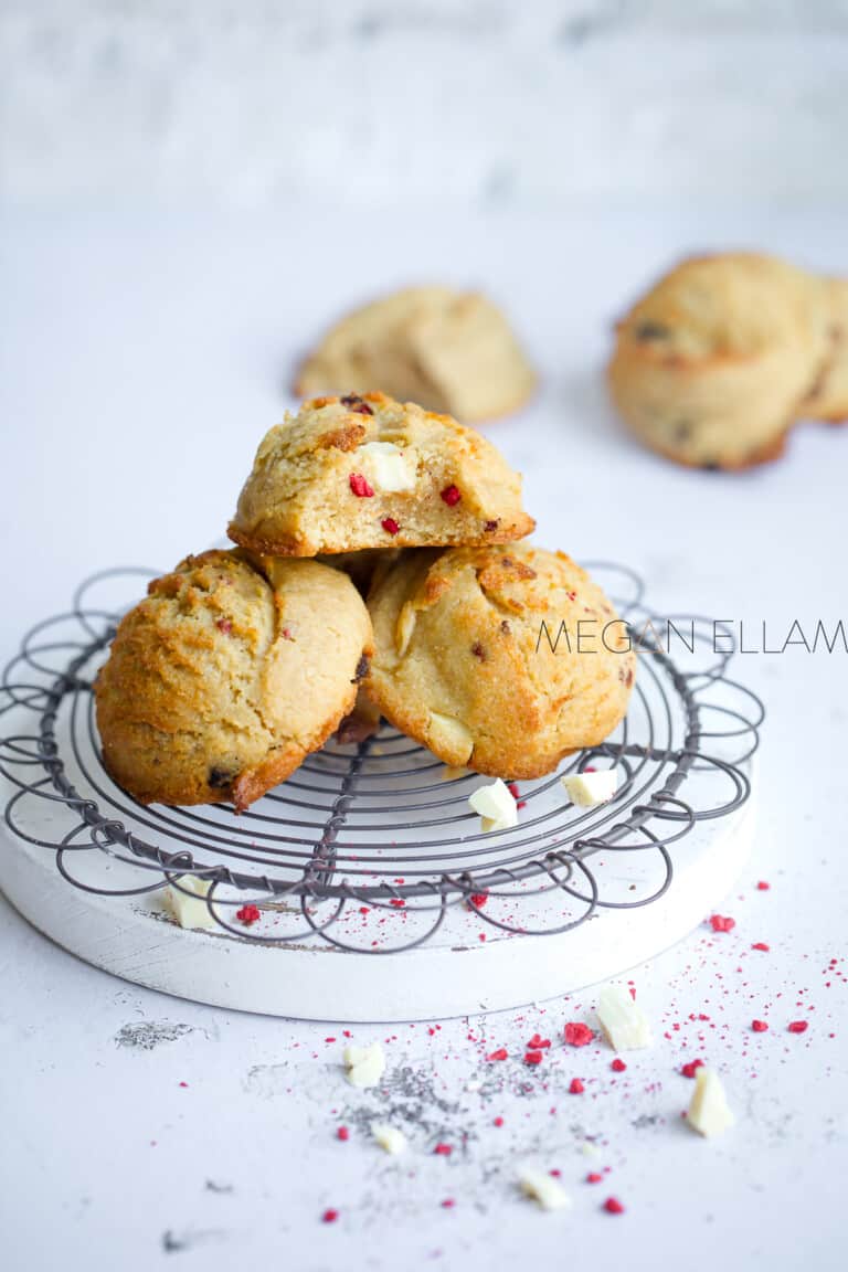 Keto White Chocolate Raspberry Cookies on a white board and wire rack.